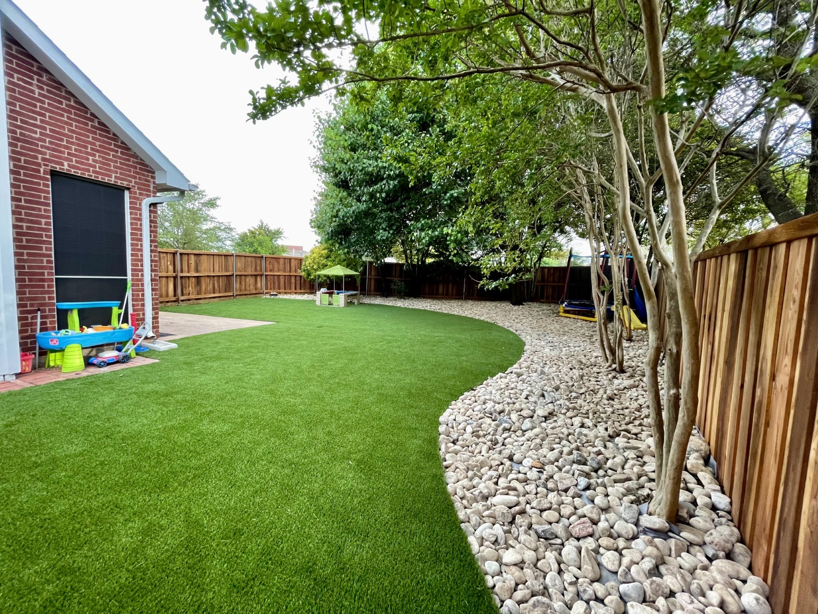 Backyard Play Haven: Kid-Friendly Turf & River Rock Installation in Frisco, TX